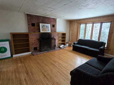 The cottage living room features a brick fireplace and two sofas.
