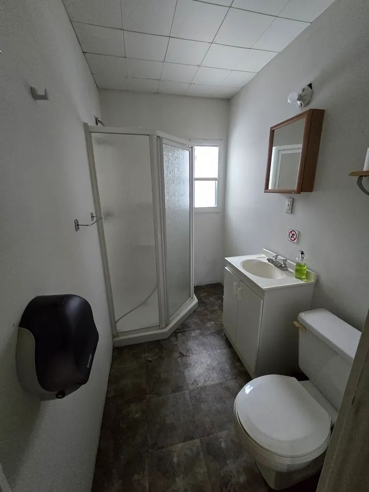 This bathroom is equipped with a shower, a sink, and a toilet.