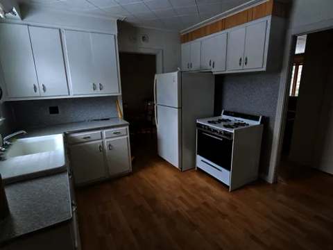 The equipped kitchen includes a refrigerator, a stove, and a sink.