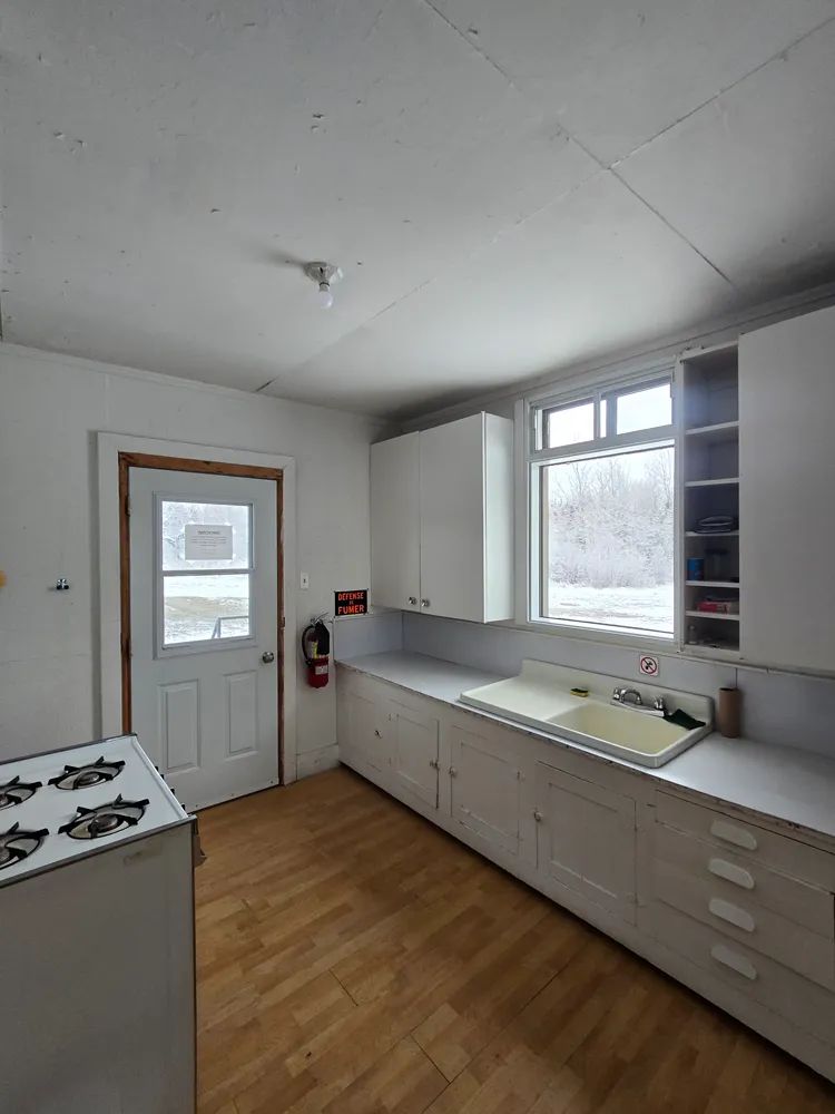 La cuisine du chalet comprend un évier, des comptoirs de rangement et une cuisinière.