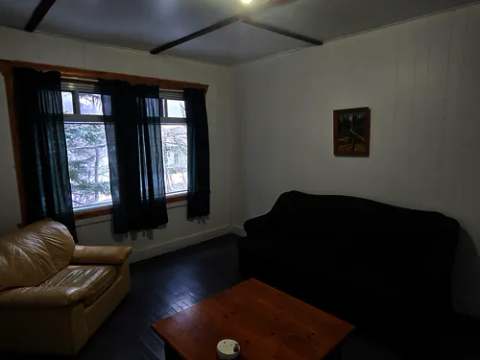 Le salon de la maison du Surintendant comprend un divan, un fauteuil et une table basse.