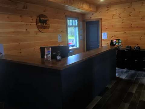 Le comptoir d'accueil du pavillon central vous reçoit dans une ambiance chaleureuse en bois.