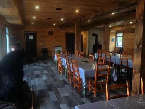 La salle à manger du pavillon central propose des tables disposées dans un espace rustique et chaleureux.