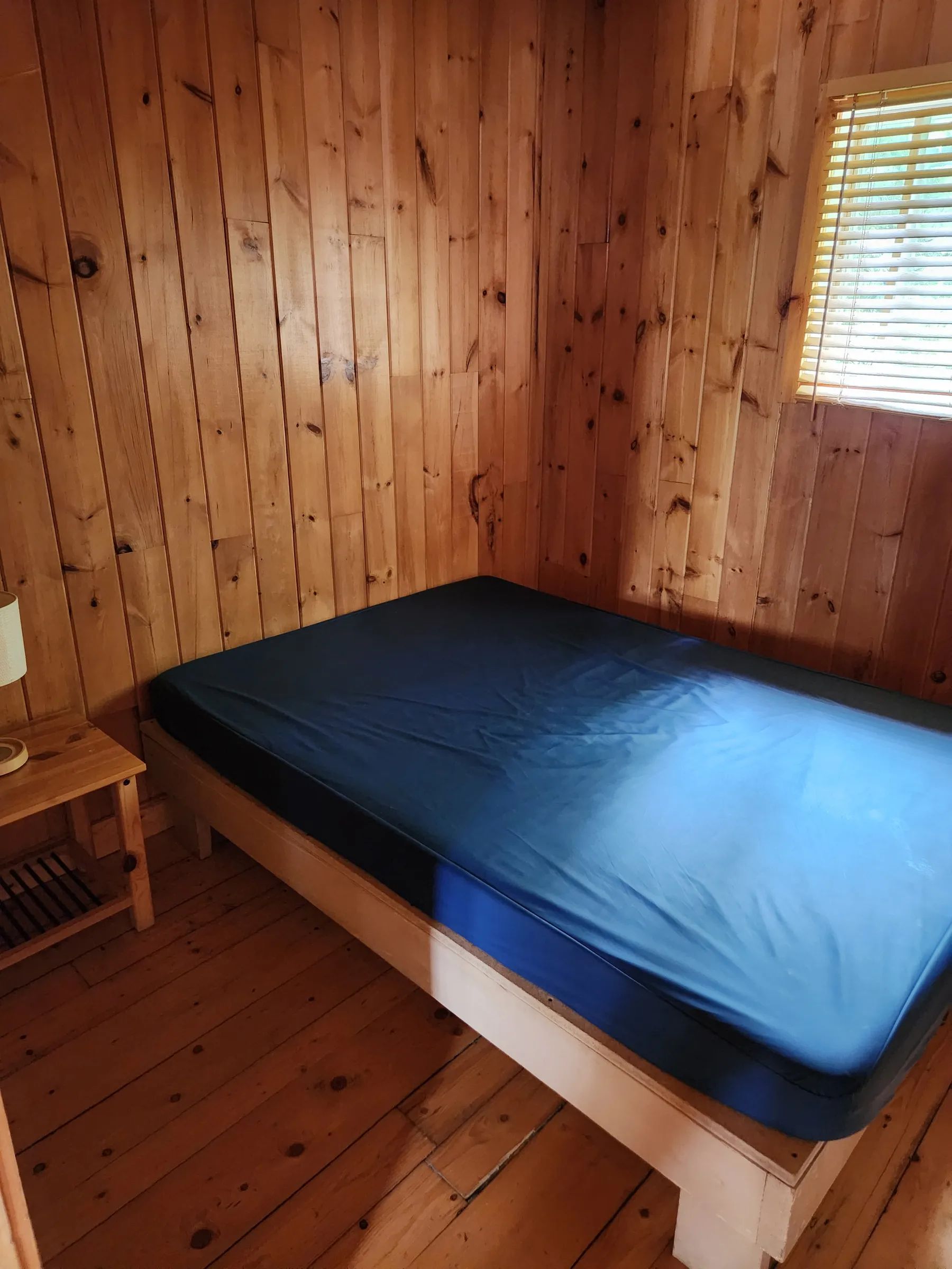 High-angle view of a bedroom with a single bed in a log cabin.