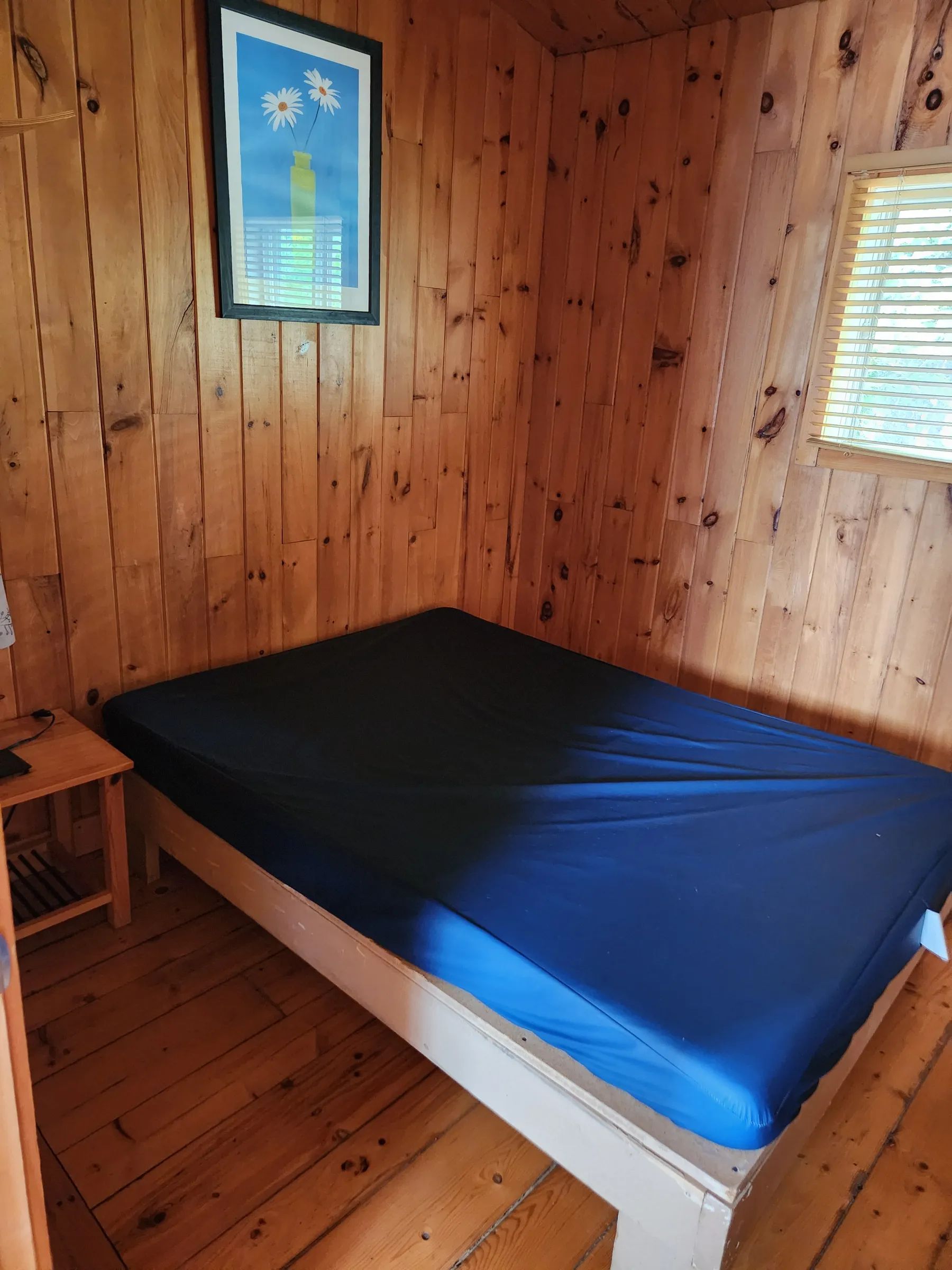High-angle view of a bedroom with a single bed in the log cabin.