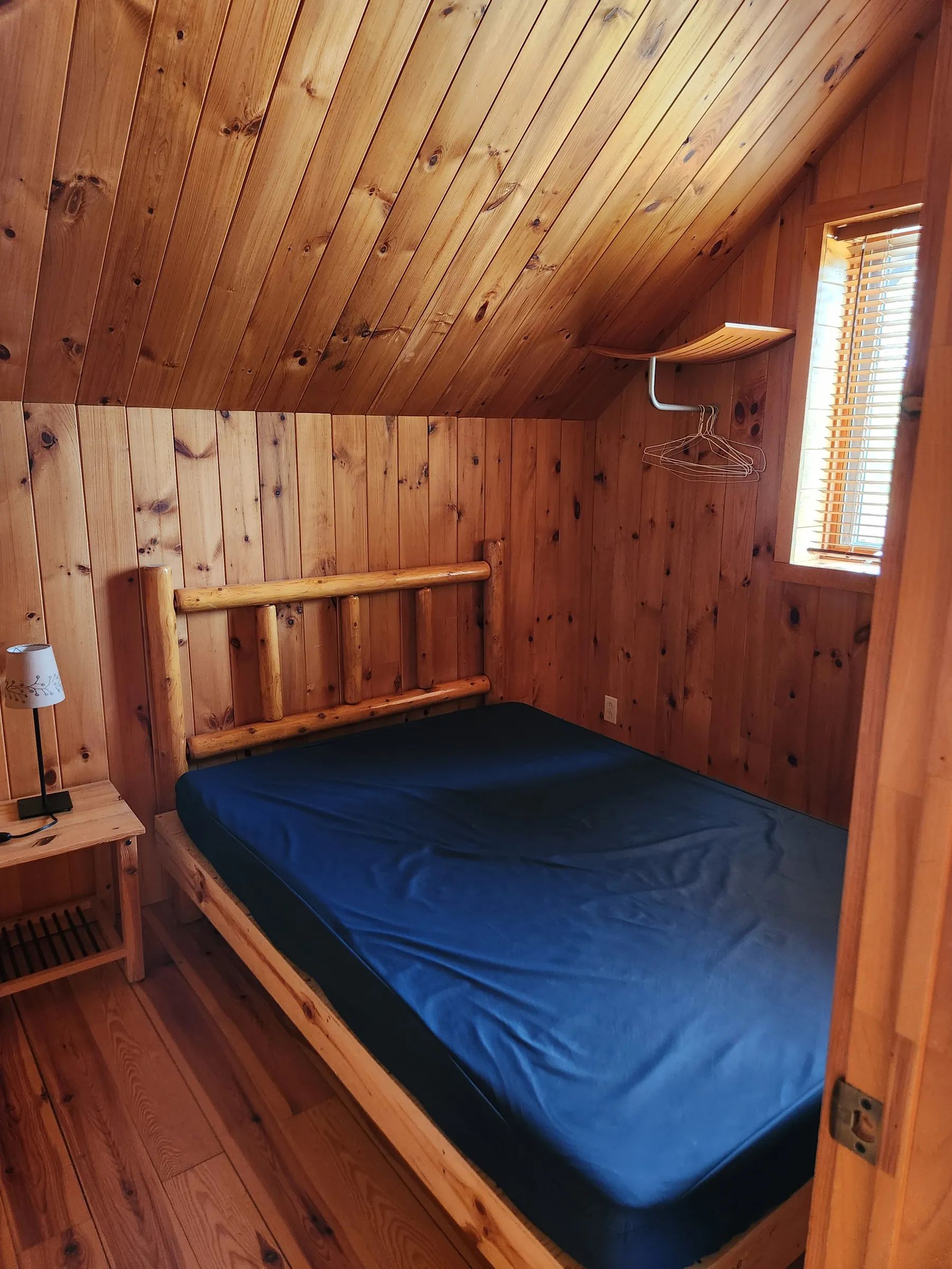 High-angle view of the loft sleeping area with wooden ladder inside the cabin.