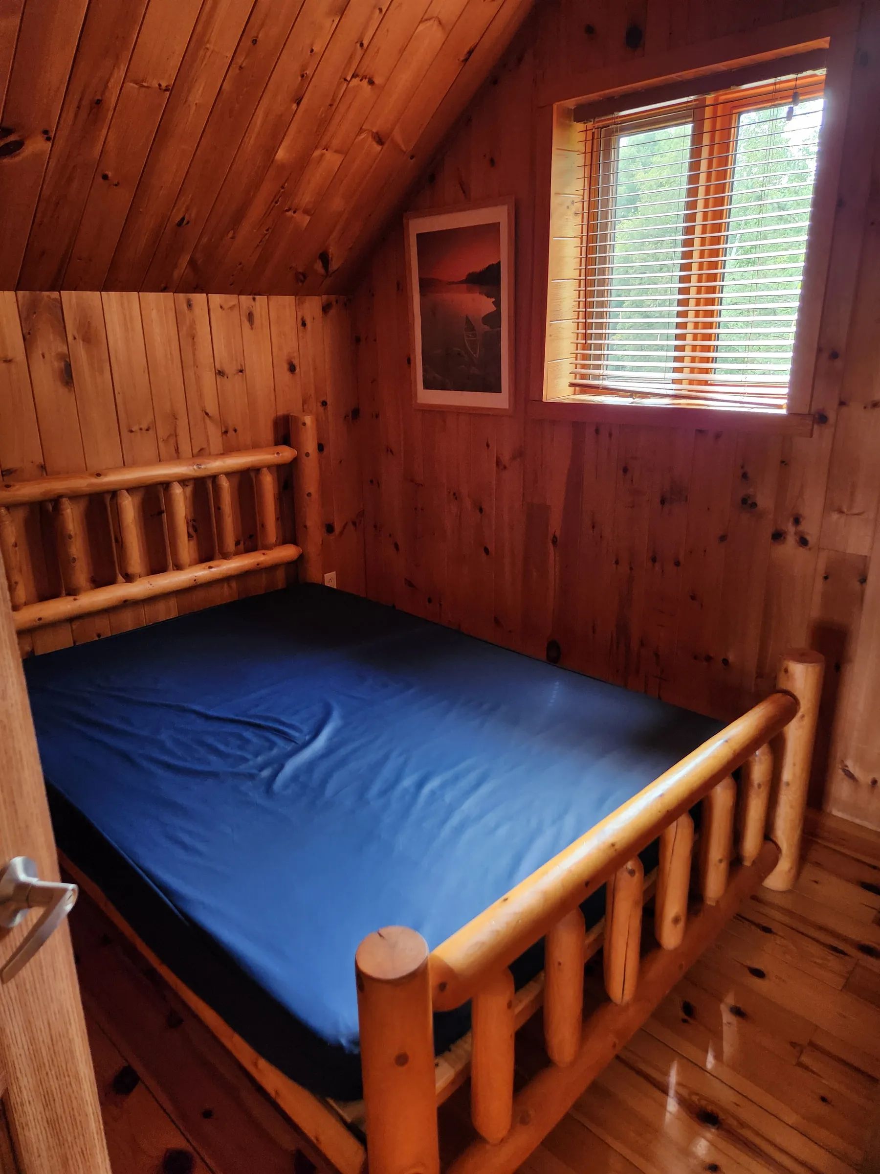 High-angle view of the loft sleeping area with wooden ladder in cabin 26.