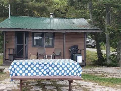 Vue extérieure du chalet avec une table de pique-nique installée à proximité.