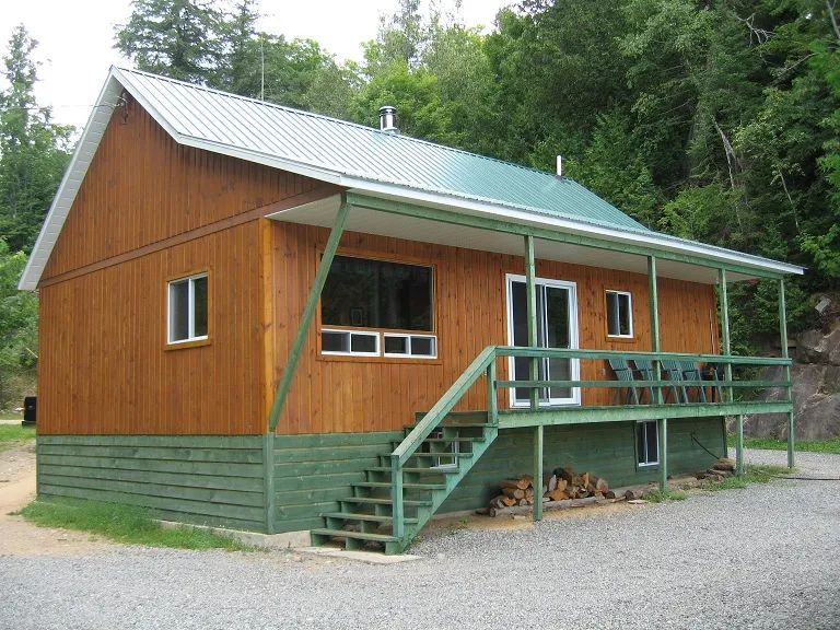 Exterior view of cottage 19 featuring its covered deck and wood siding.