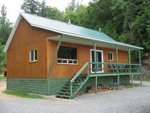 Exterior view of cottage 19 featuring its covered deck and wood siding.
