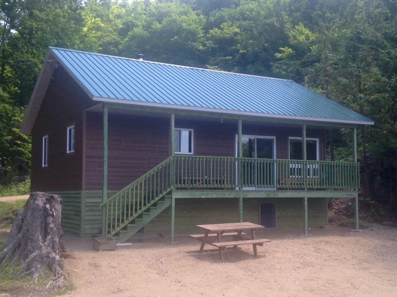 Exterior view of cottage 19 featuring its covered porch and a nearby picnic table.