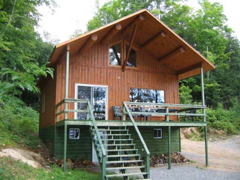 Exterior view of the cottage with its raised deck and access staircase.