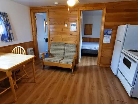 Vue de l'espace de vie principal incluant la cuisine, le salon et l'accès aux chambres du chalet.