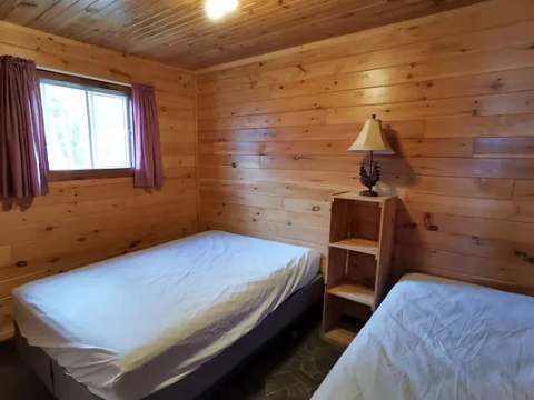 This rustic wooden bedroom features two single beds.
