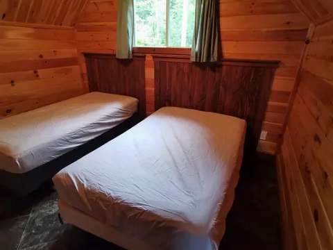 This rustic bedroom features two single beds with wooden headboards.