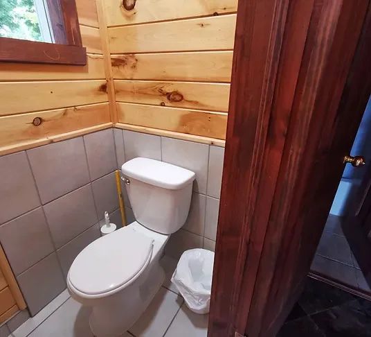 View of the functional bathroom with wood and ceramic walls inside the cabin.