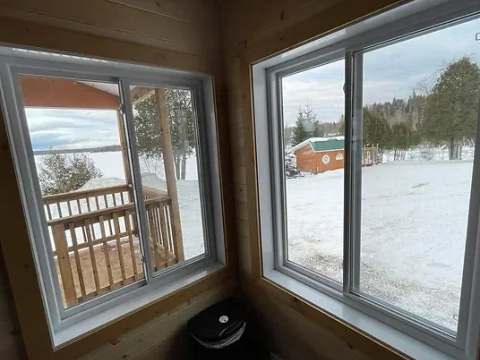 Vue sur le paysage enneigé depuis l'intérieur du chalet.