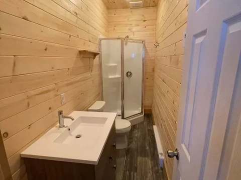 La salle de bain du chalet comprend une douche, une toilette et un meuble-lavabo.