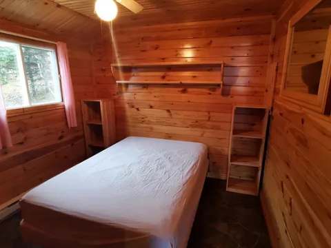Cette chambre rustique est équipée d'un lit double et de rangement mural en bois.