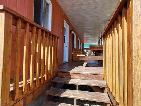The covered veranda of cabin number 5 offers an outdoor space to enjoy nature.