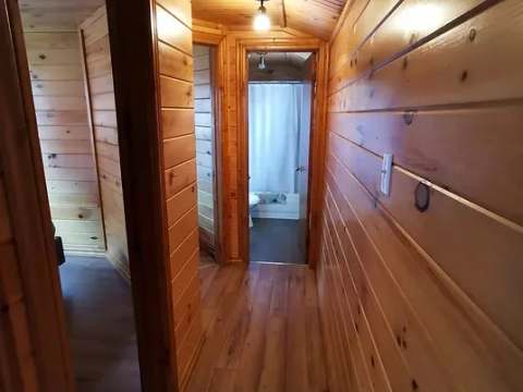 Un corridor en bois mène vers la salle de bain du chalet.