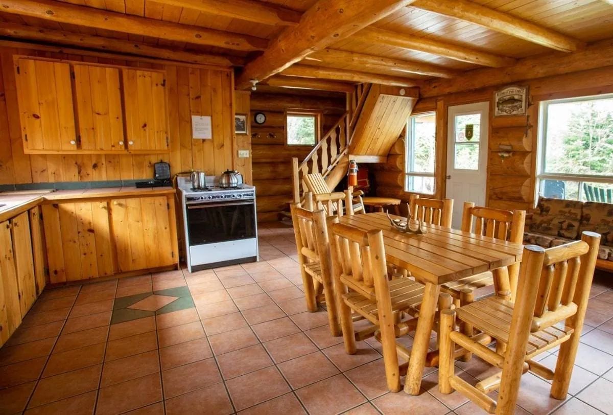 The chalet kitchen and dining area feature an open concept with wooden furniture.