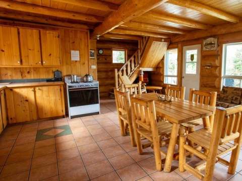 The chalet kitchen and dining area feature an open concept with wooden furniture.