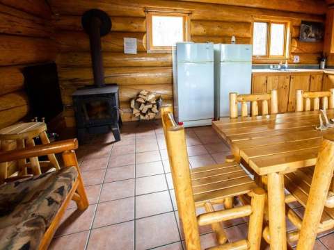 Kitchenette and dining area with a wood stove in the log cabin.