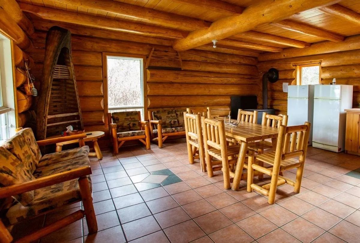 The open-concept chalet area features a dining room and a living area with log furniture.