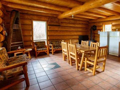 The open-concept chalet area features a dining room and a living area with log furniture.