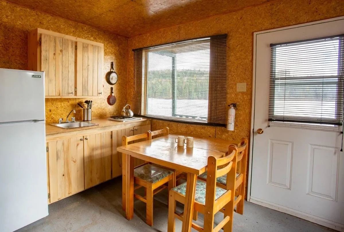 The functional kitchenette in the cabin includes a dining table, a refrigerator, and a sink.