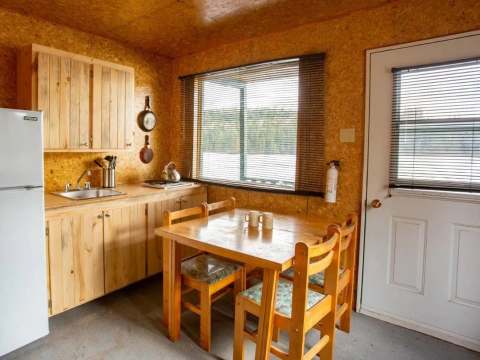 The functional kitchenette in the cabin includes a dining table, a refrigerator, and a sink.