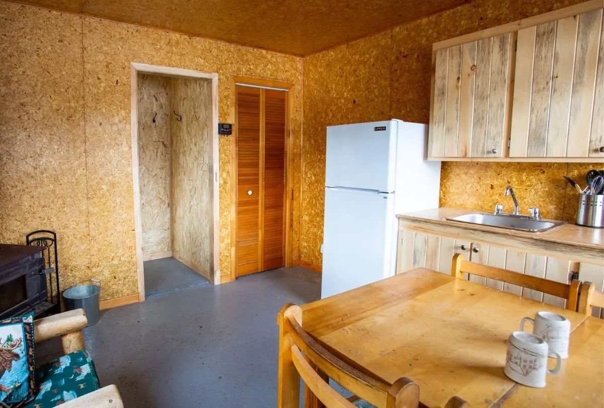 View of the rustic kitchen and dining table inside the cabin.