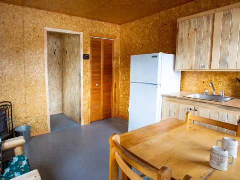 View of the rustic kitchen and dining table inside the cabin.