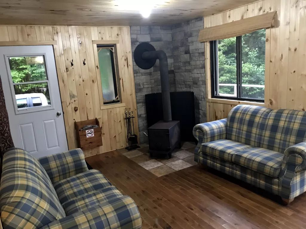 Le salon du chalet Hiya comprend des sofas confortables et un poêle à bois.