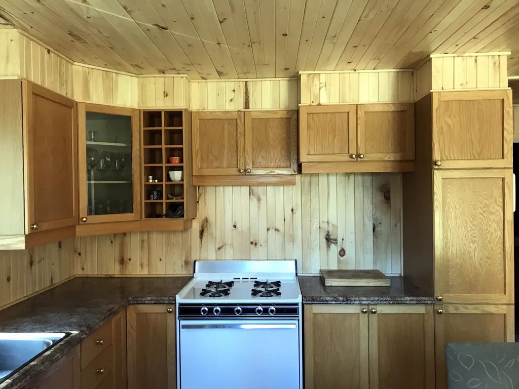 La cuisine équipée du chalet dispose d'armoires en bois et d'une cuisinière fonctionnelle.