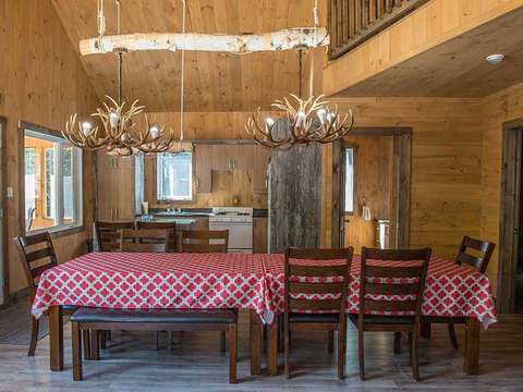 The dining room of the Boreal chalet features a large wooden table with rustic chairs.