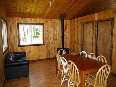 Chalet living area with dining space, lounge and wood stove.