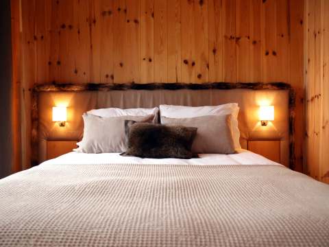 The Boreal room features a large bed with wooden panel walls and warm lighting.