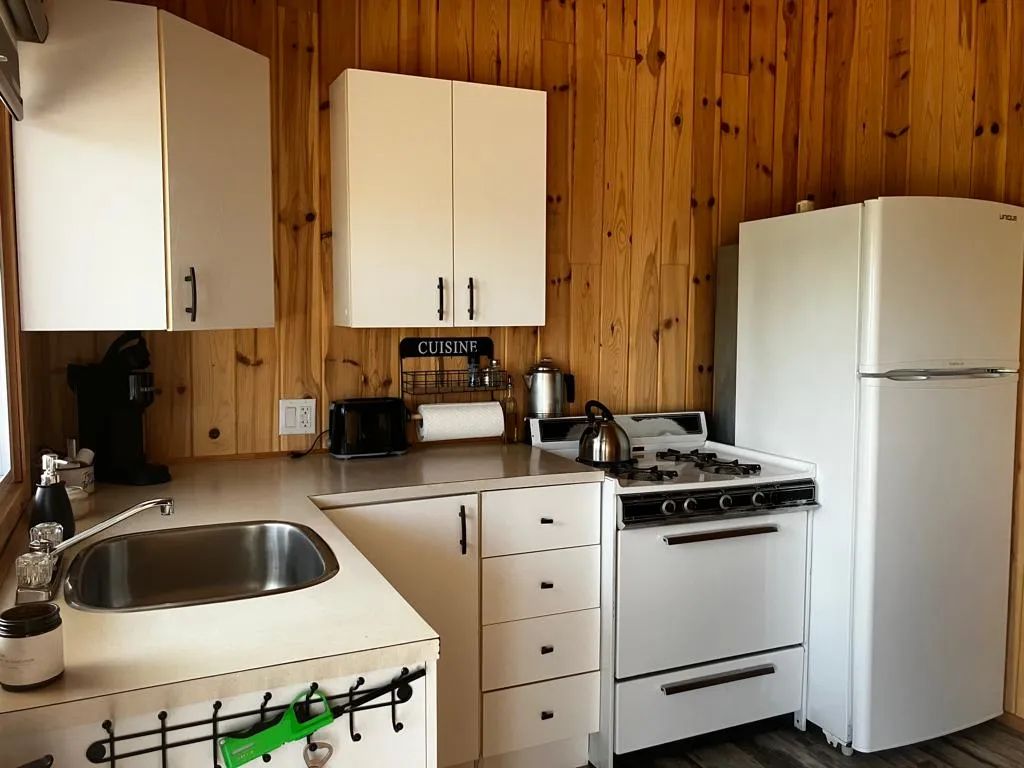 The chalet's equipped kitchen features a stove, refrigerator, and a functional countertop.