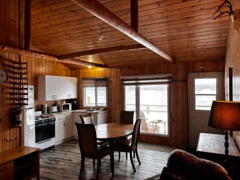 The open area features a functional kitchen and a dining table with a view of the outdoors.