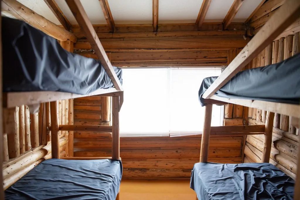 Cette chambre rustique est équipée de deux lits superposés en bois rond.