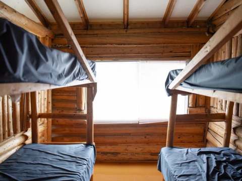 Cette chambre rustique est équipée de deux lits superposés en bois rond.