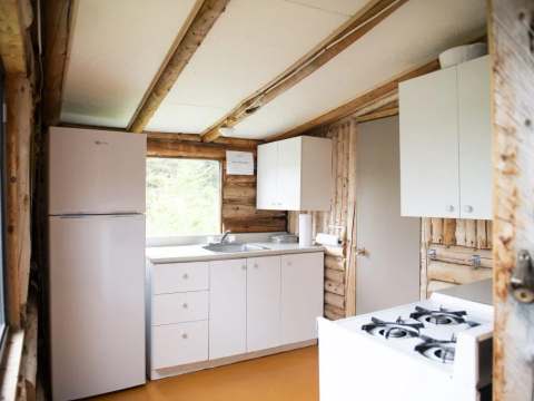 La cuisine fonctionnelle du chalet est équipée d'un réfrigérateur et d'une cuisinière.