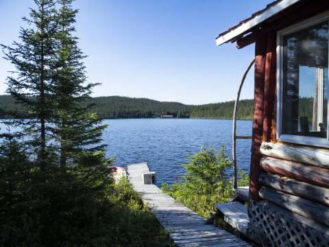 La vue sur le lac et le quai depuis l'extérieur du chalet.