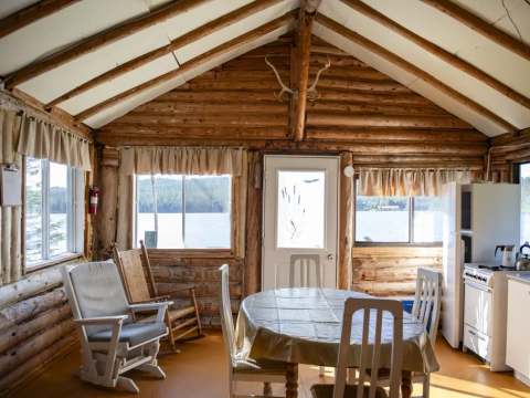 La salle à manger du chalet dispose d'une table, de chaises et d'une vue sur le lac.
