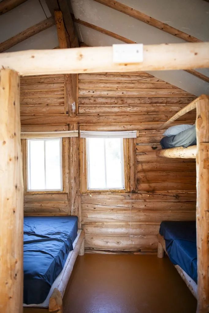 L'intérieur rustique du chalet 3 comprend des lits avec literie.