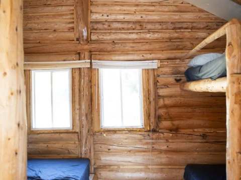 L'intérieur rustique du chalet 3 comprend des lits avec literie.