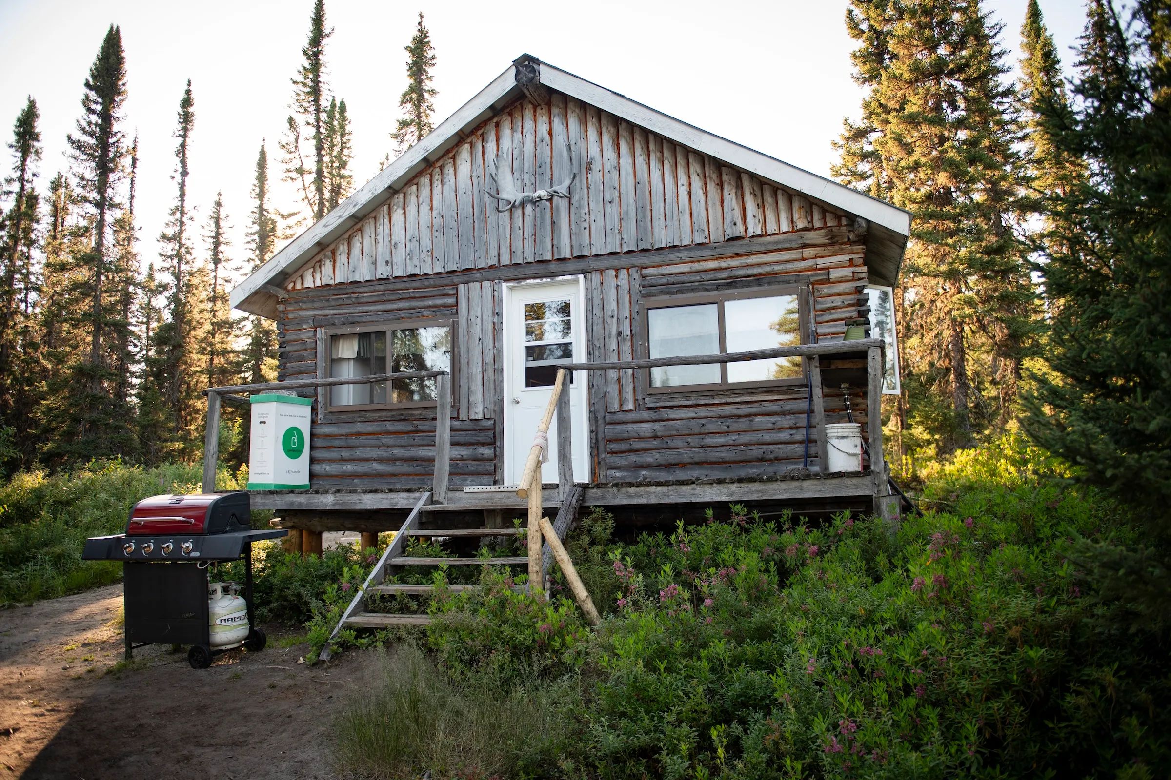 Façade du chalet La moucheté avec son entrée, sa galerie et un barbecue à disposition.