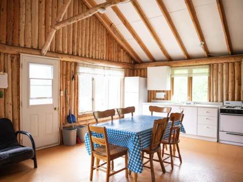 L'aire ouverte du chalet comprend une salle à manger, une cuisine fonctionnelle et un coin salon.